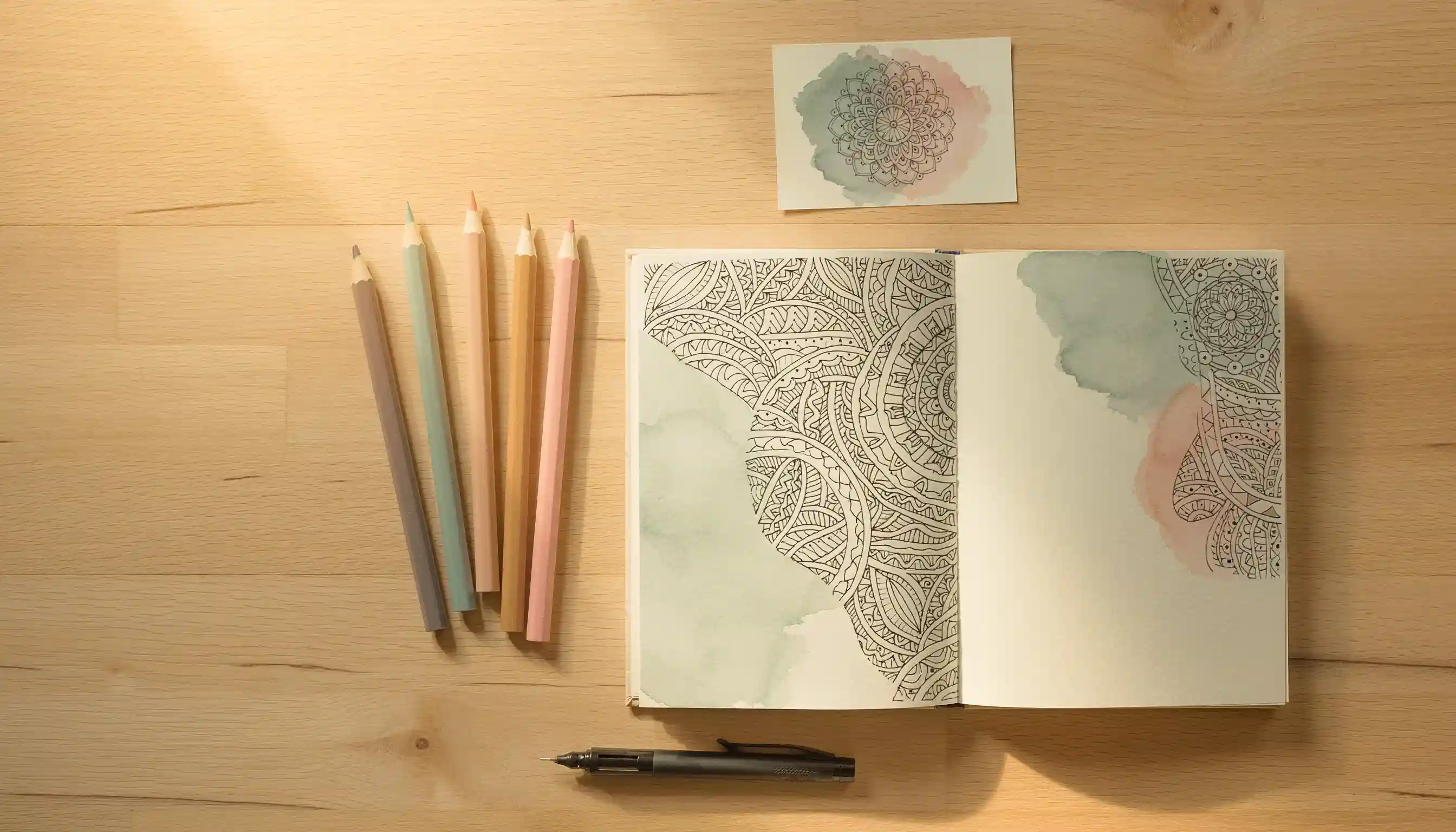 Carnet ouvert avec motifs zentangle et crayons de couleur pour exercices d'art-thérapie